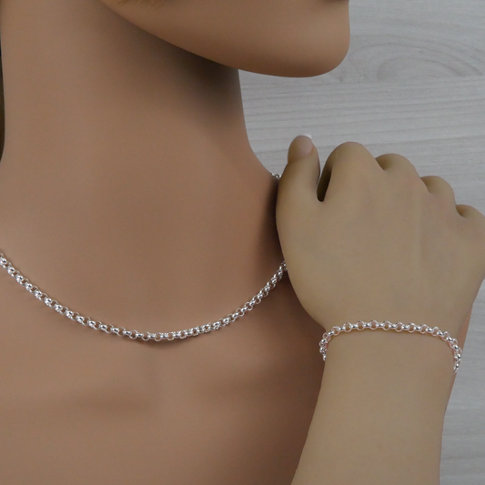 Silver rolo necklace and bracelet on a mannequin with a neutral background