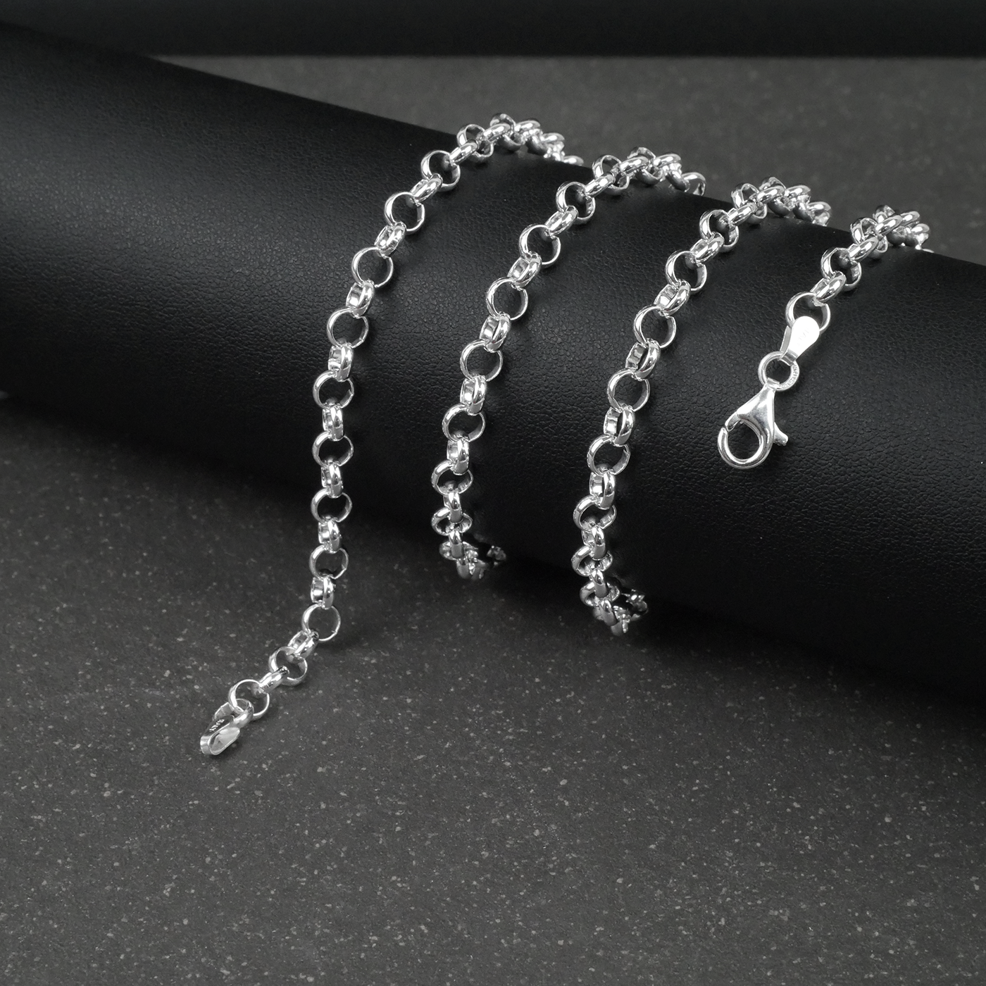 Silver rolo/belcher chain bracelet on a dark surface