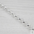 Close-up of a silver bracelet on a light grey background