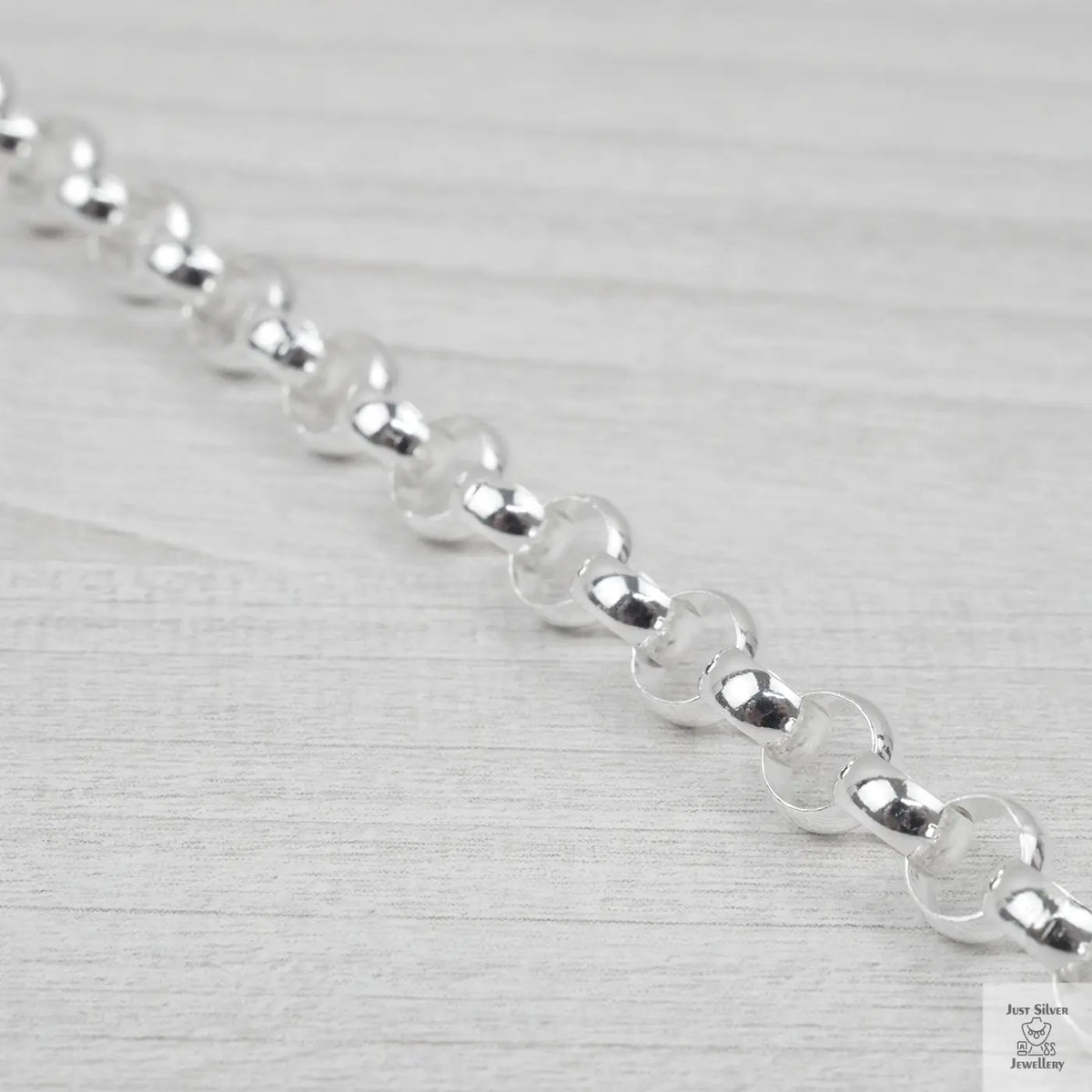 Close-up of a silver bracelet on a light grey background