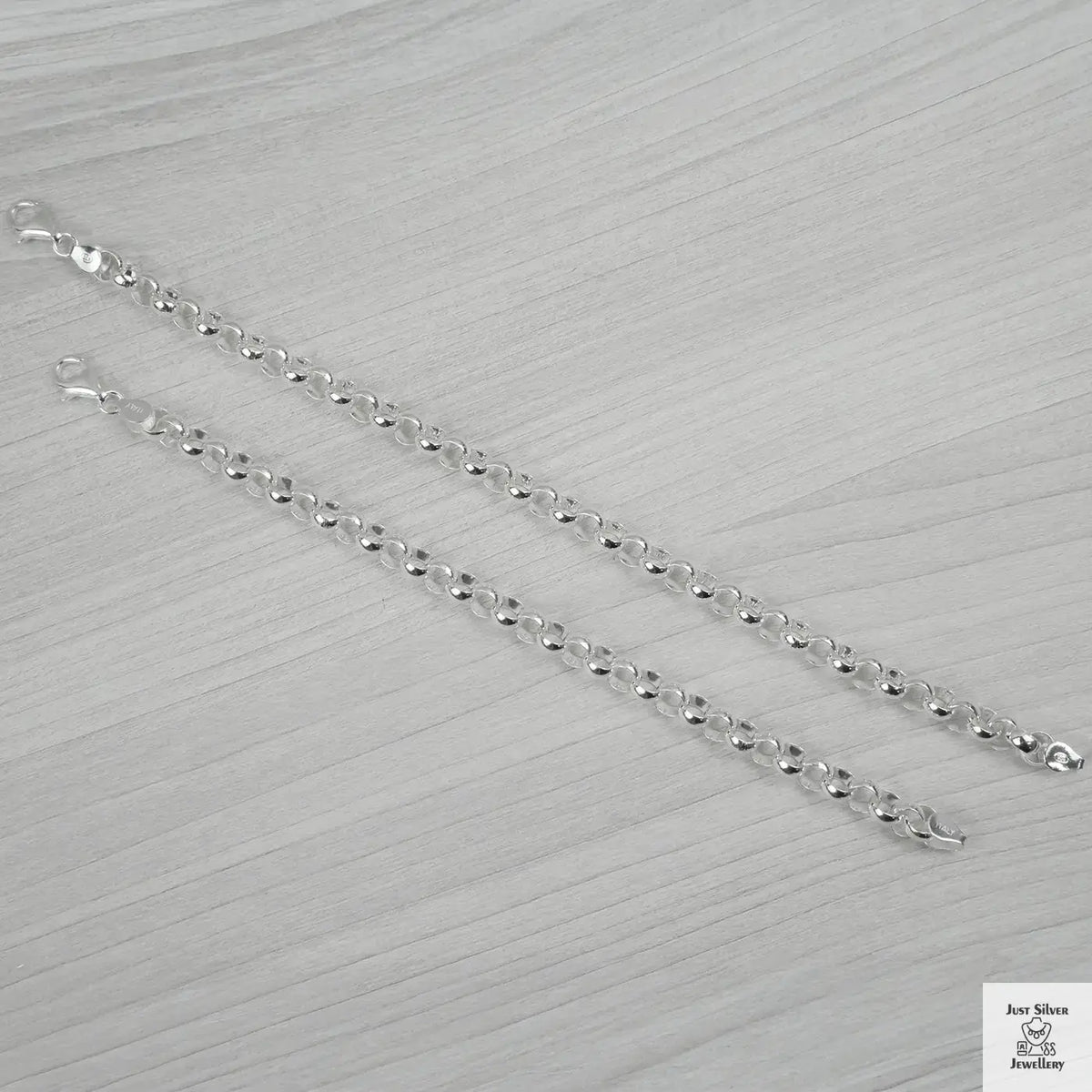 Silver bracelets on a light grey textured surface