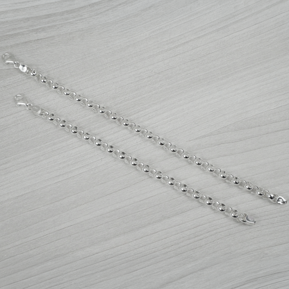 Silver bracelets on a light grey textured surface