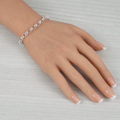 Silver bracelet on a mannequin hand with a neutral background