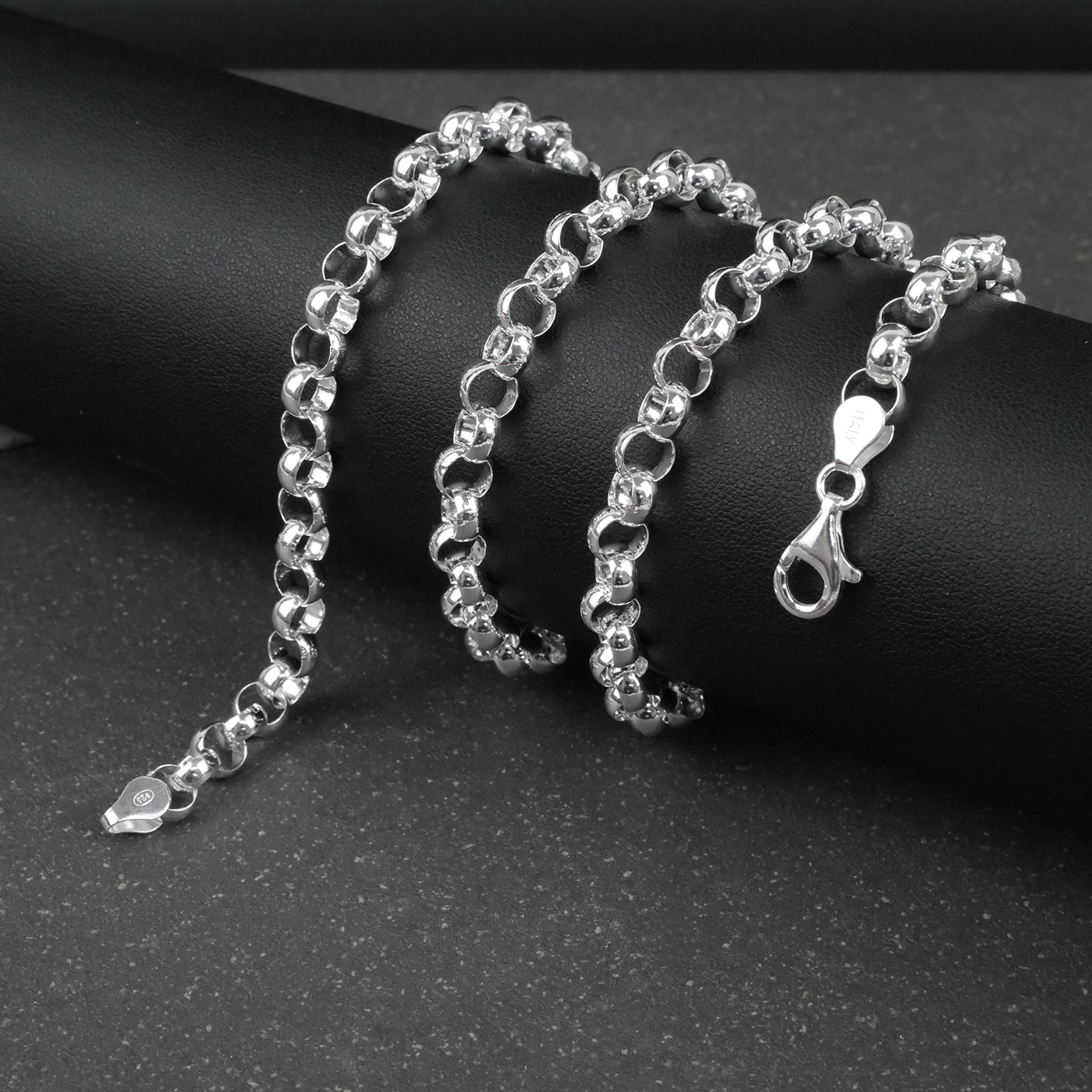 Silver rolo/belcher chain necklace on a dark surface