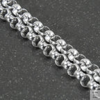 Close-up of a silver beaded necklace on a light gray background