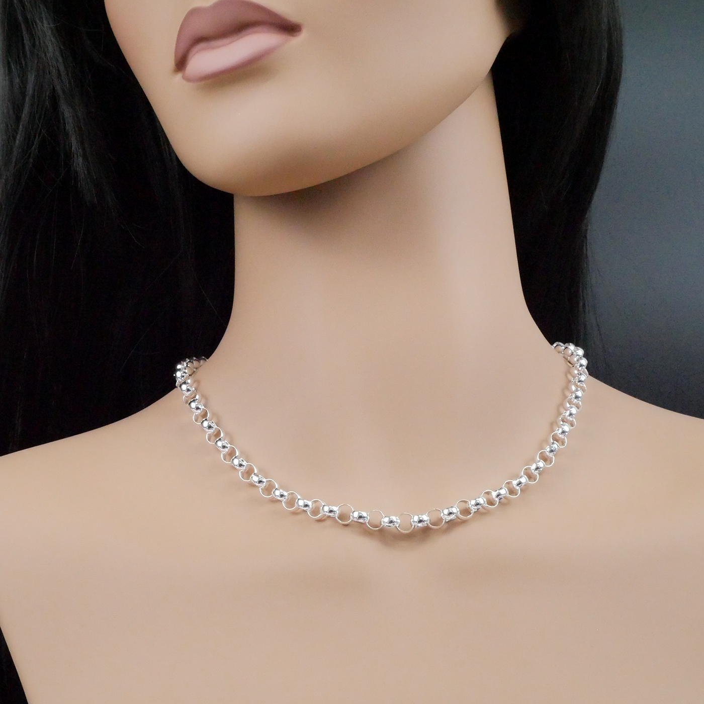 Mannequin wearing a silver necklace on a dark background