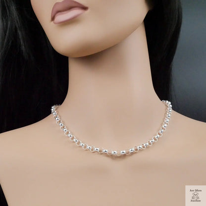 Mannequin wearing a silver necklace on a dark background