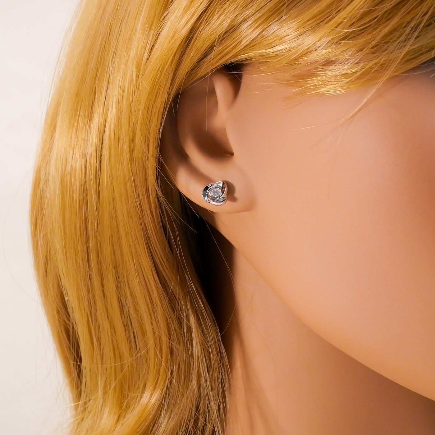 Close-up of a person wearing a silver earring with blonde hair.