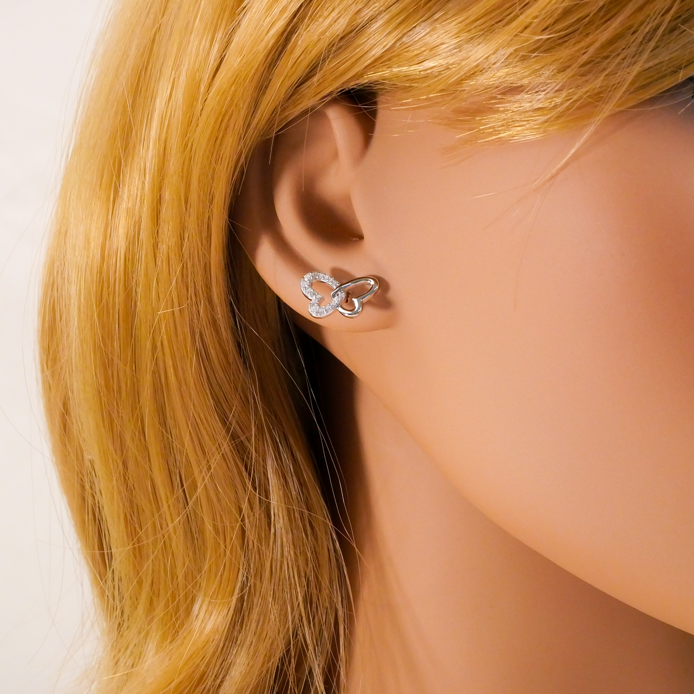 Butterfly-shaped earring worn by a mannequin with blonde hair.