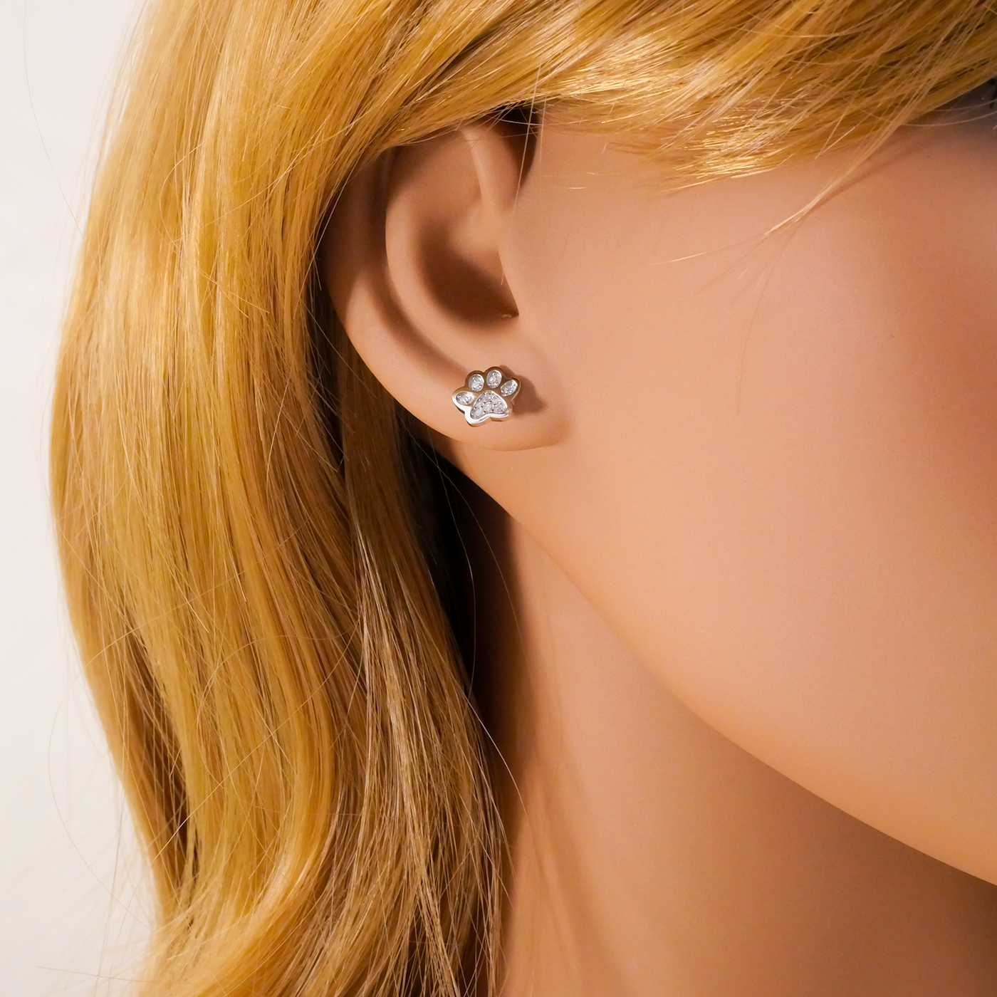 Paw print earring worn on a mannequin with blonde hair