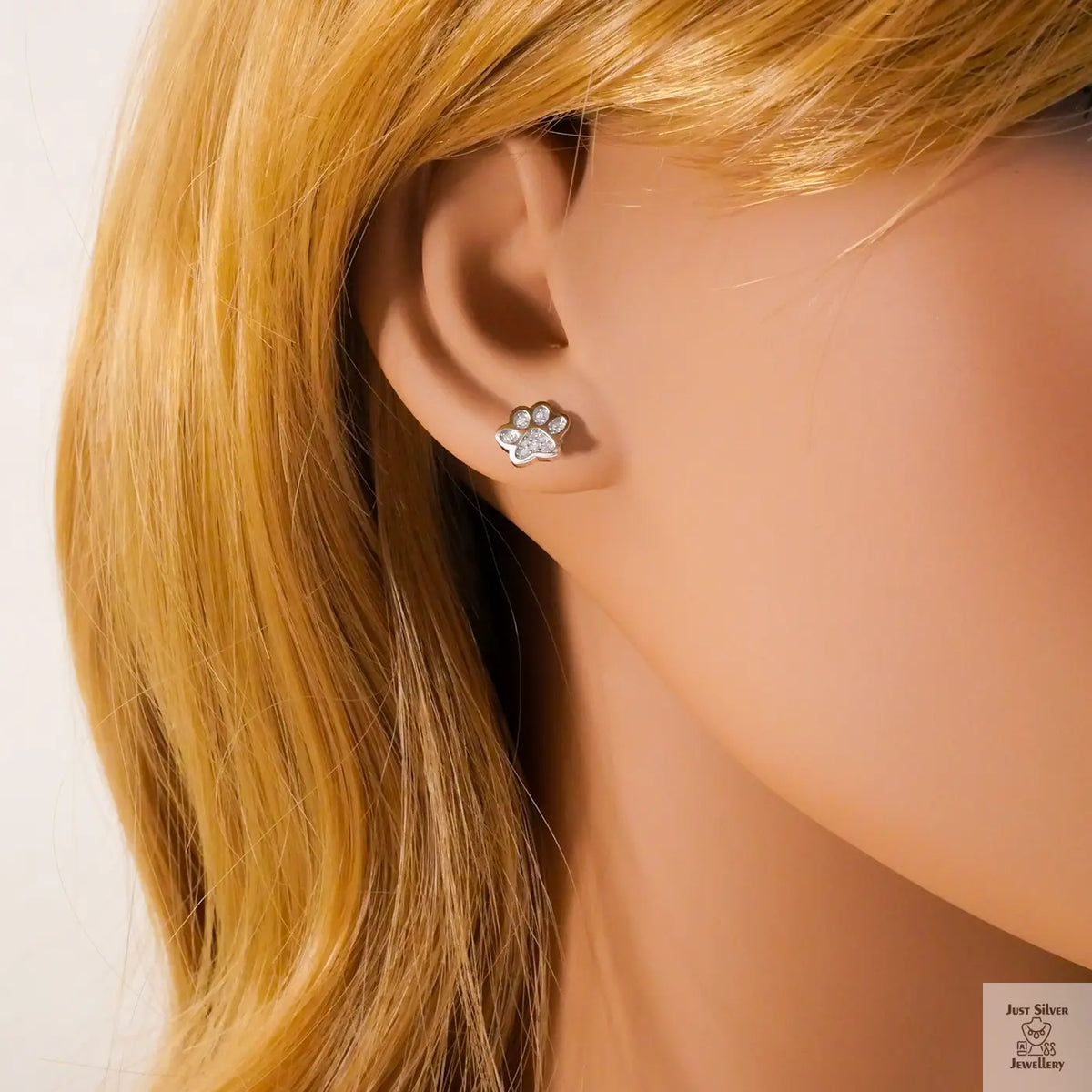 Paw print earring worn on a mannequin with blonde hair