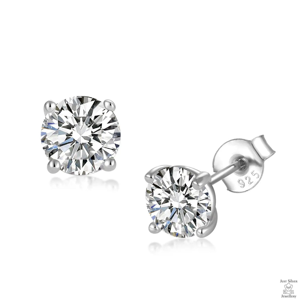 Pair of silver stud earrings with clear natural zircon gemstones on a white background