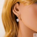 Close-up of a person wearing a heart-shaped earring with blonde hair.