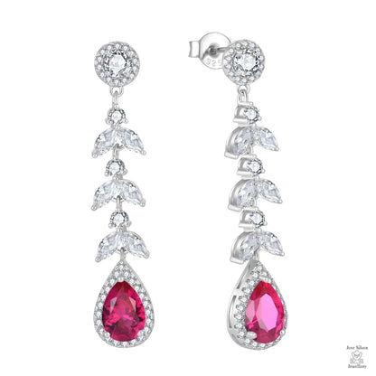 Pair of earrings with red teardrop zircon stones and leaves on a white background
