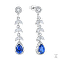 Pair of silver earrings with blue teardrop natural zircon on a white background