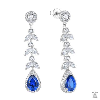 Pair of silver earrings with blue teardrop natural zircon on a white background