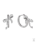 Silver bow-shaped earrings with clear zircon gemstones on a white background