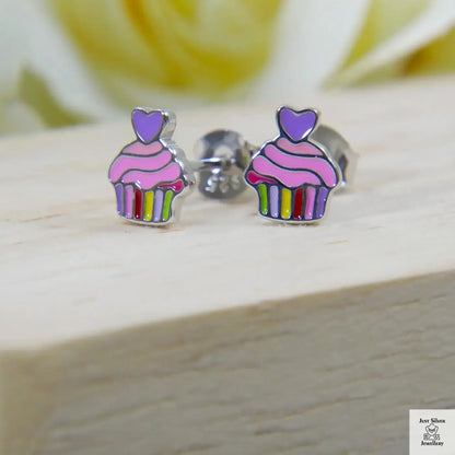 Cupcake-shaped earrings with colorful stripes on a wooden surface