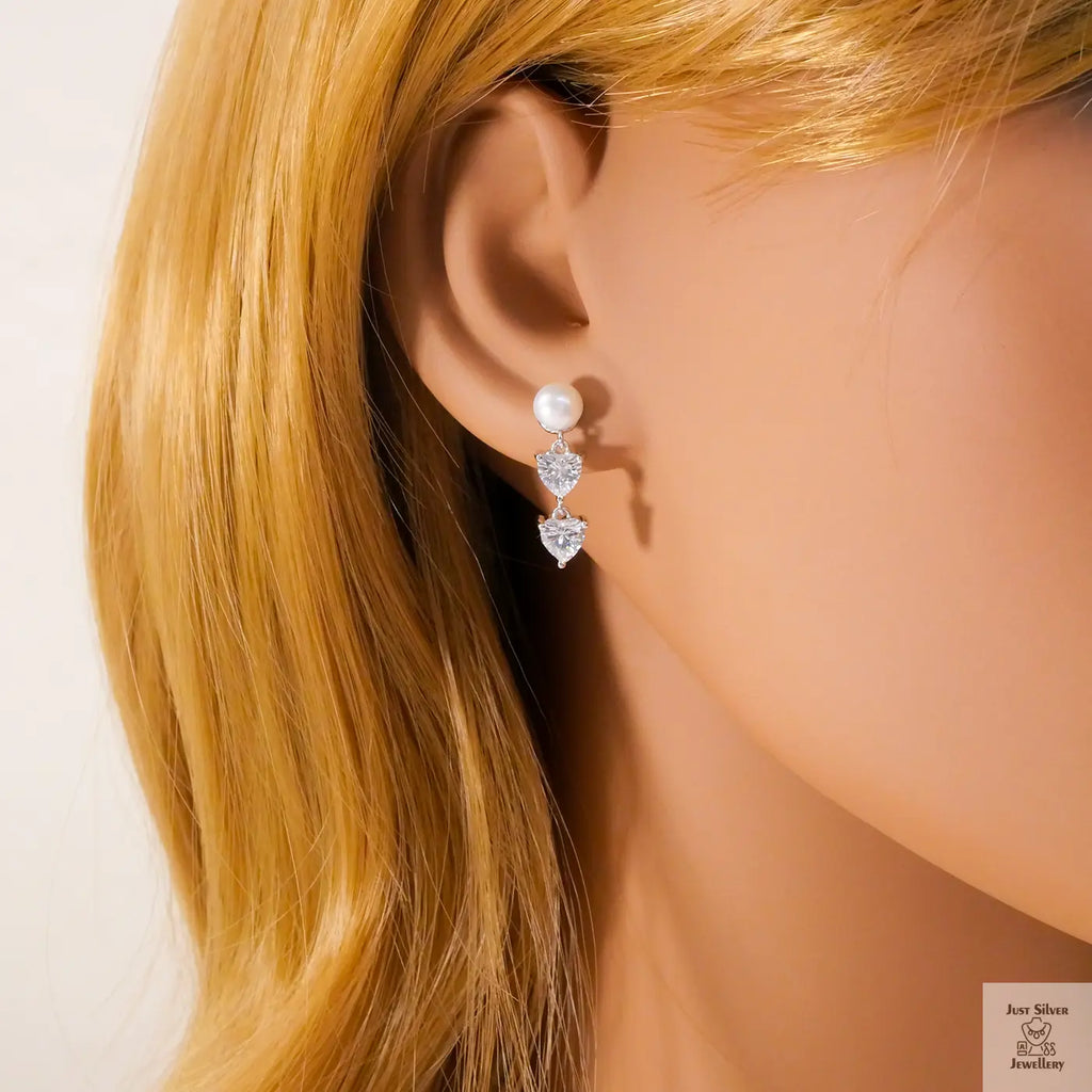 Pearl and heart-shaped Natural Zircon gemstone earrings on a mannequin with blonde hair.