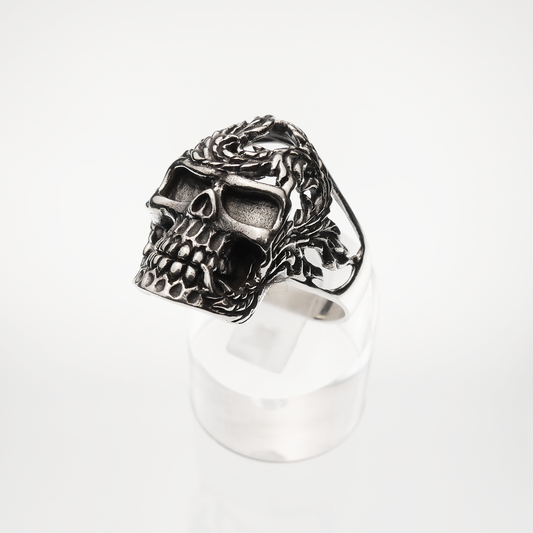 Silver skull ring with intricate design on a white background