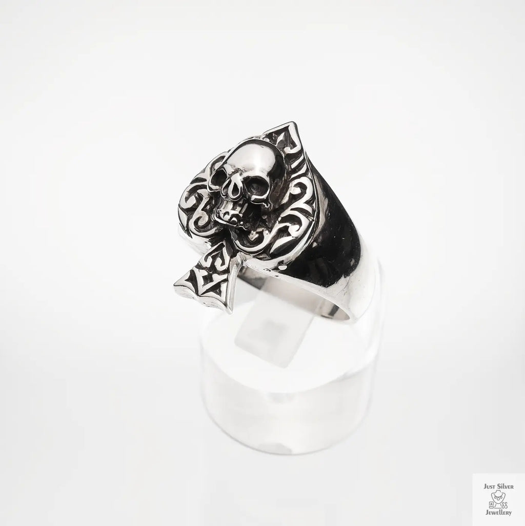 Silver skull ring with intricate designs on a white background