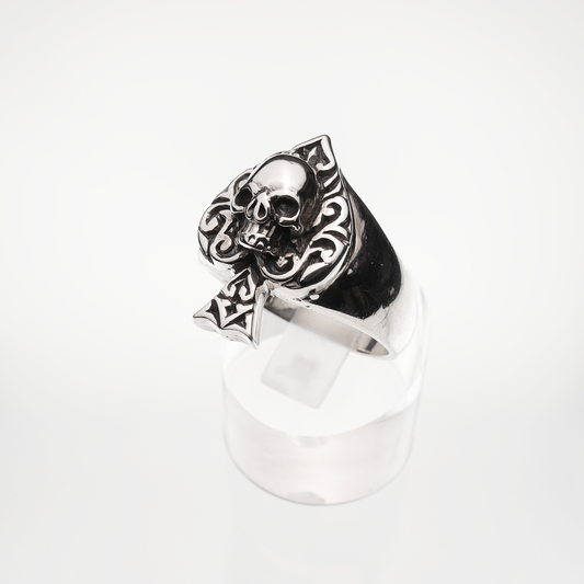 Silver skull ring with intricate designs on a white background