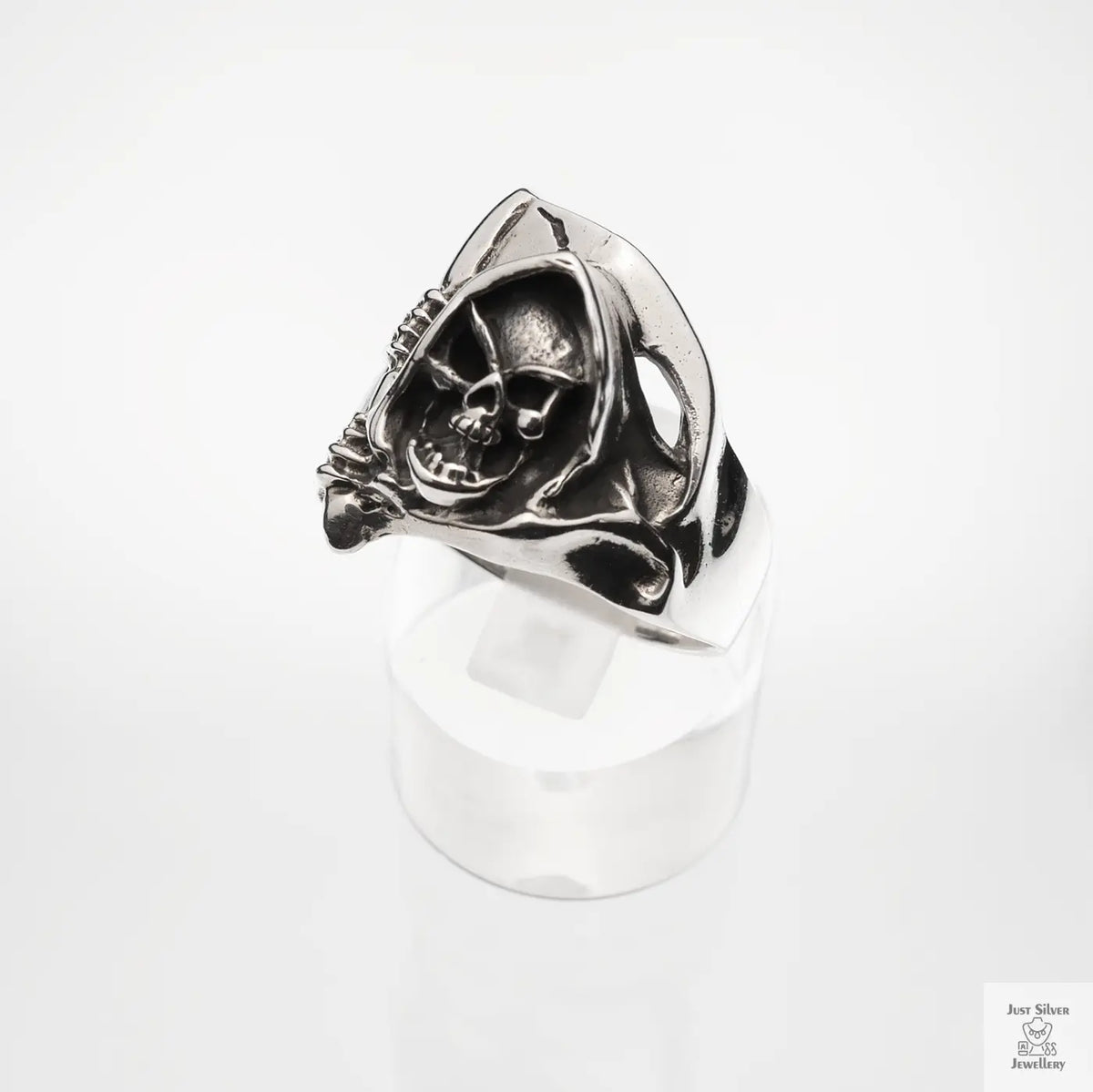 Silver ring with skull design on a white background