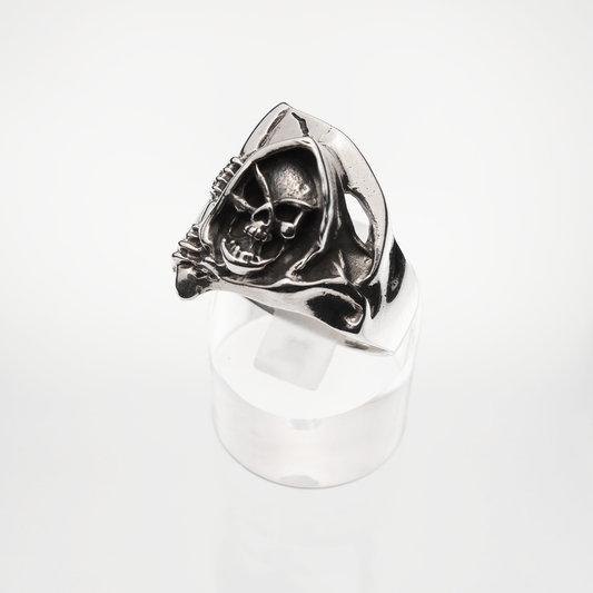 Silver ring with skull design on a white background
