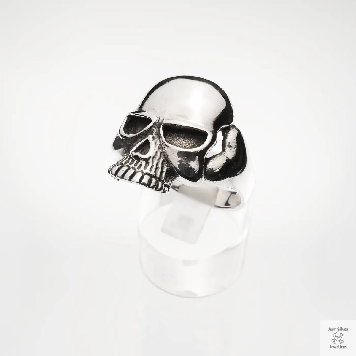 Silver skull-shaped ring on a white background