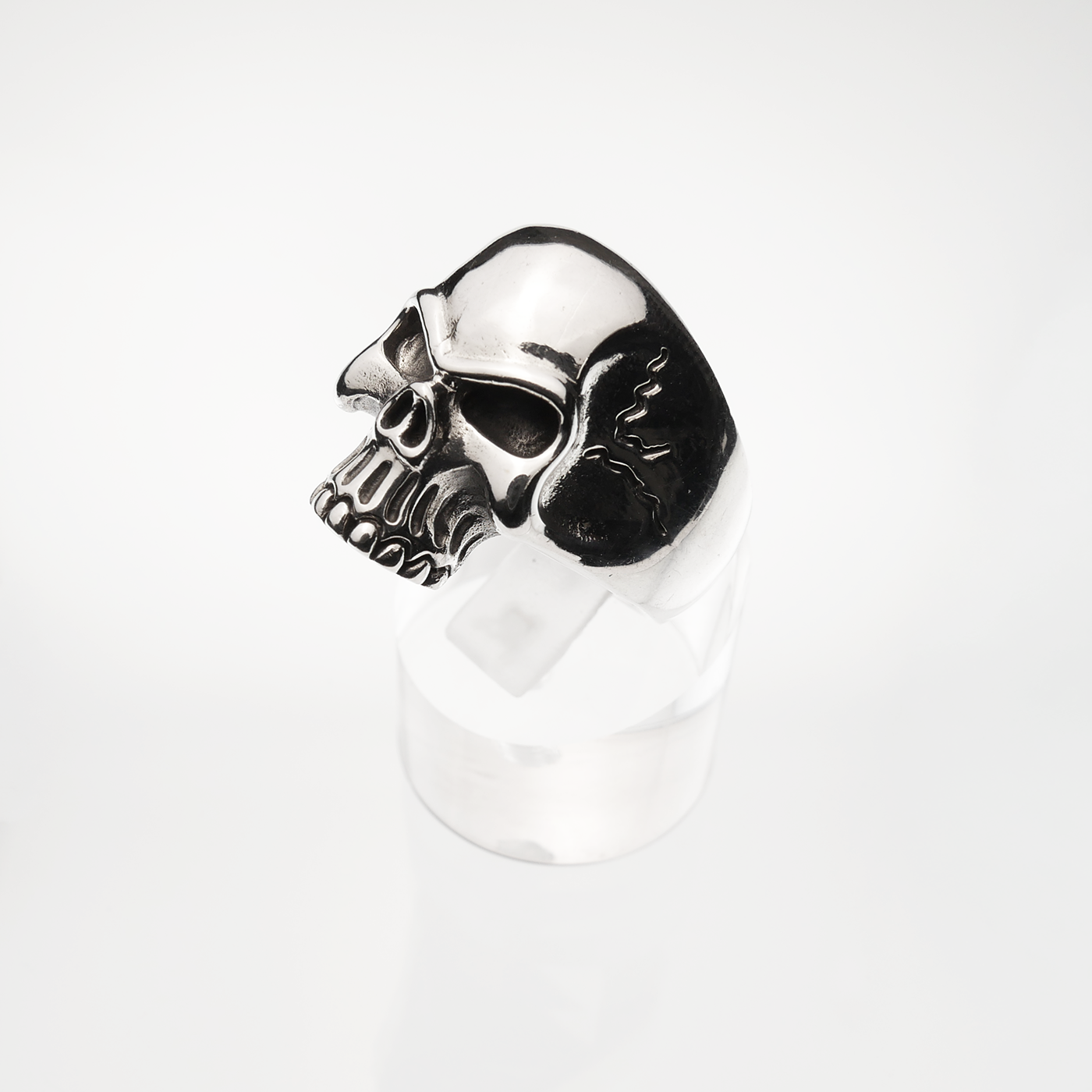 Skull-shaped silver ring on a white background