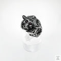 Silver skull ring with red stones on a white background