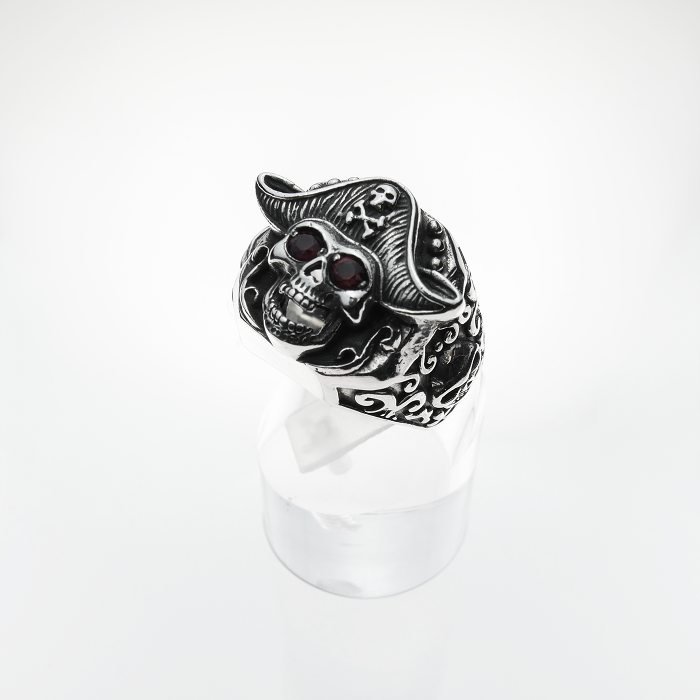 Silver skull ring with red stones on a white background