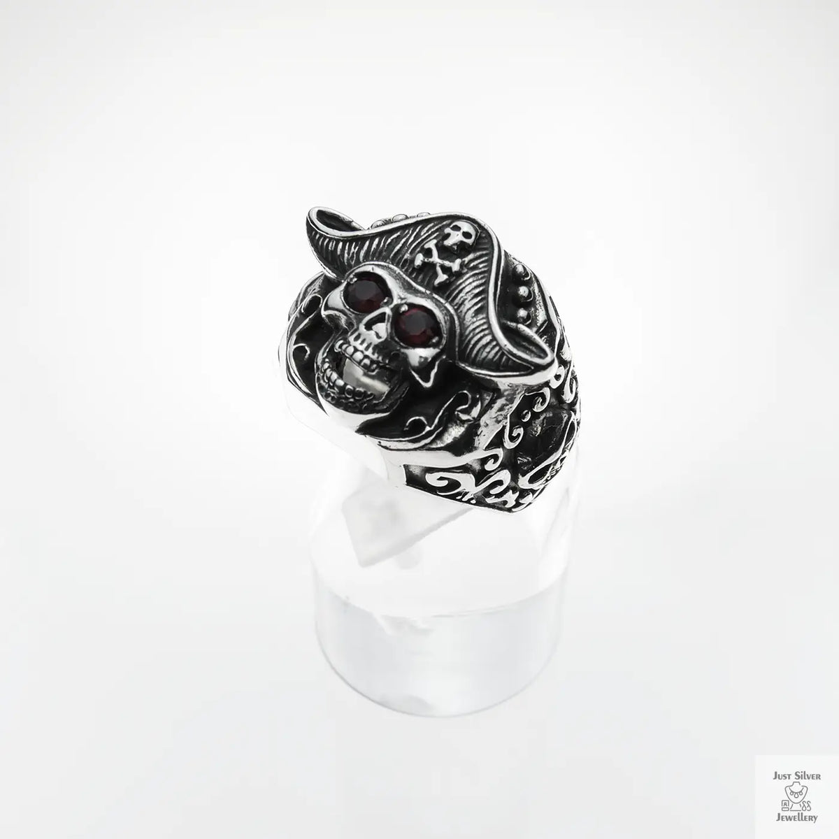 Silver skull ring with red stones on a white background