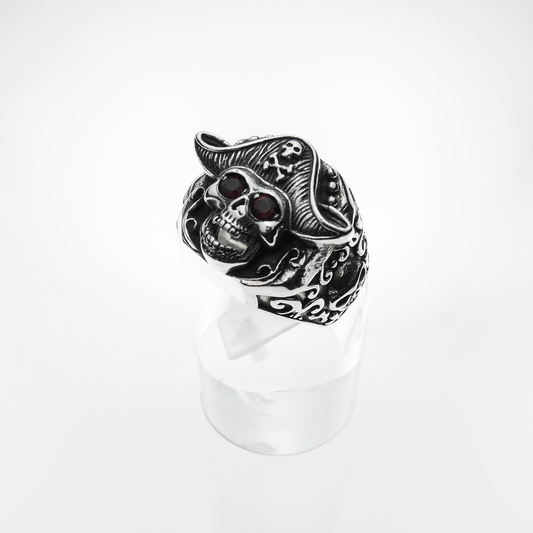 Silver skull ring with red stones on a white background