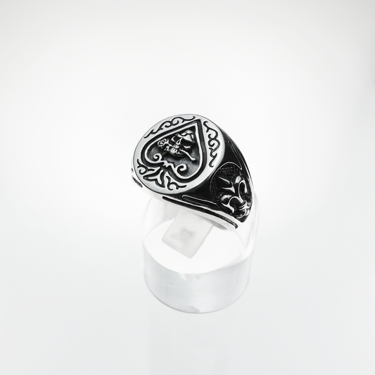 Silver ring with intricate design on a white background