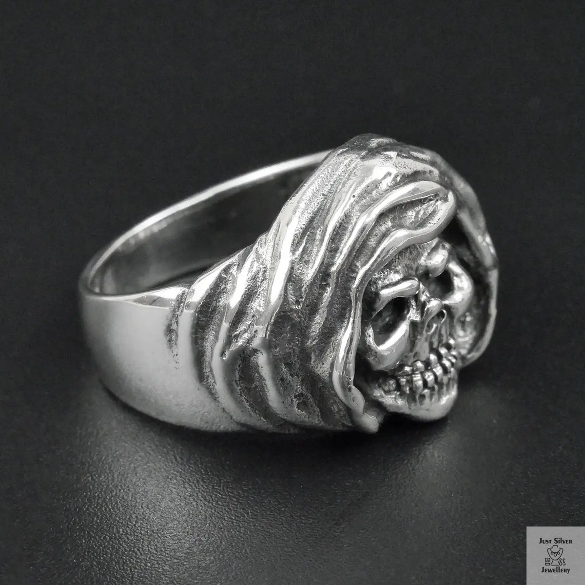 Silver skull ring on a black background