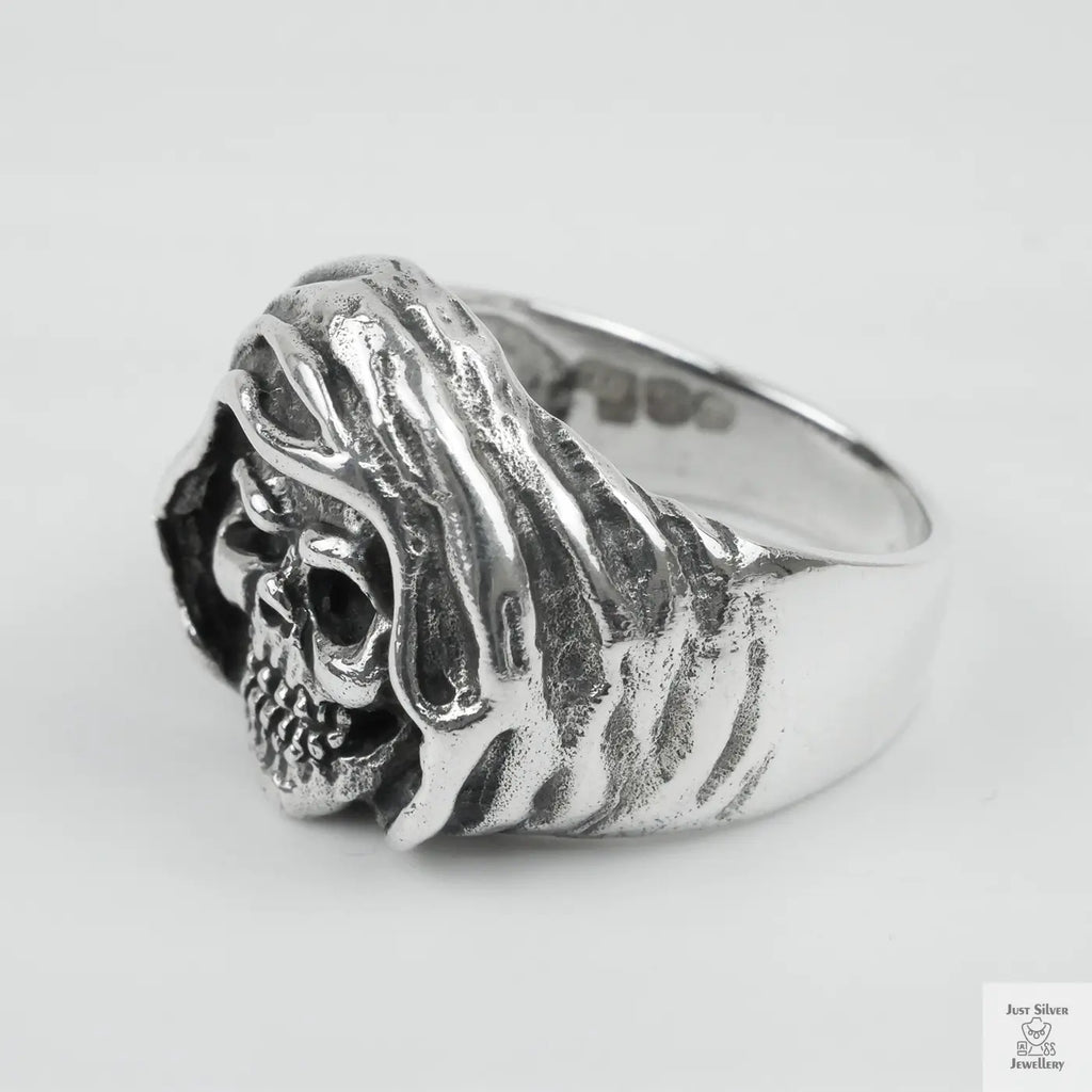 Silver ring with a detailed design on a white background