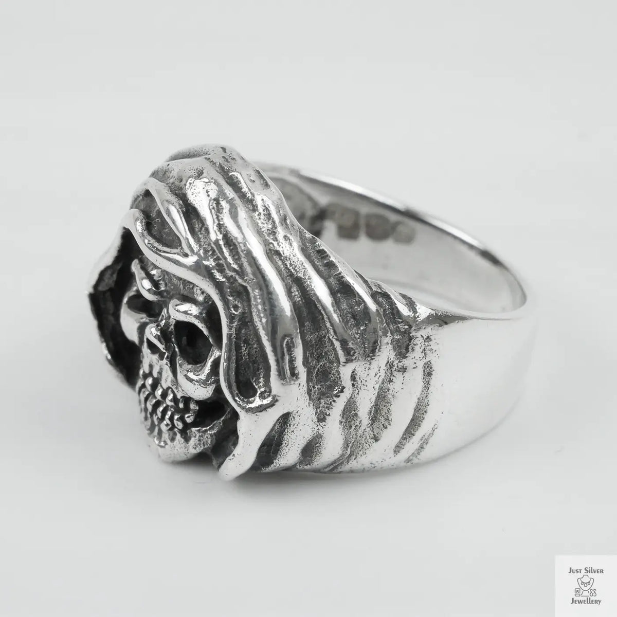 Silver ring with a detailed design on a white background