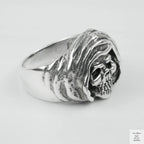 Silver ring with skull design on a light grey background