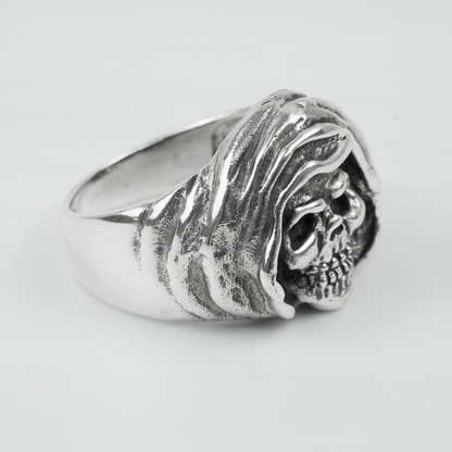 Silver ring with skull design on a light grey background