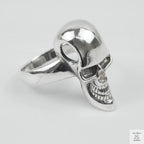 Silver skull ring on a light grey background