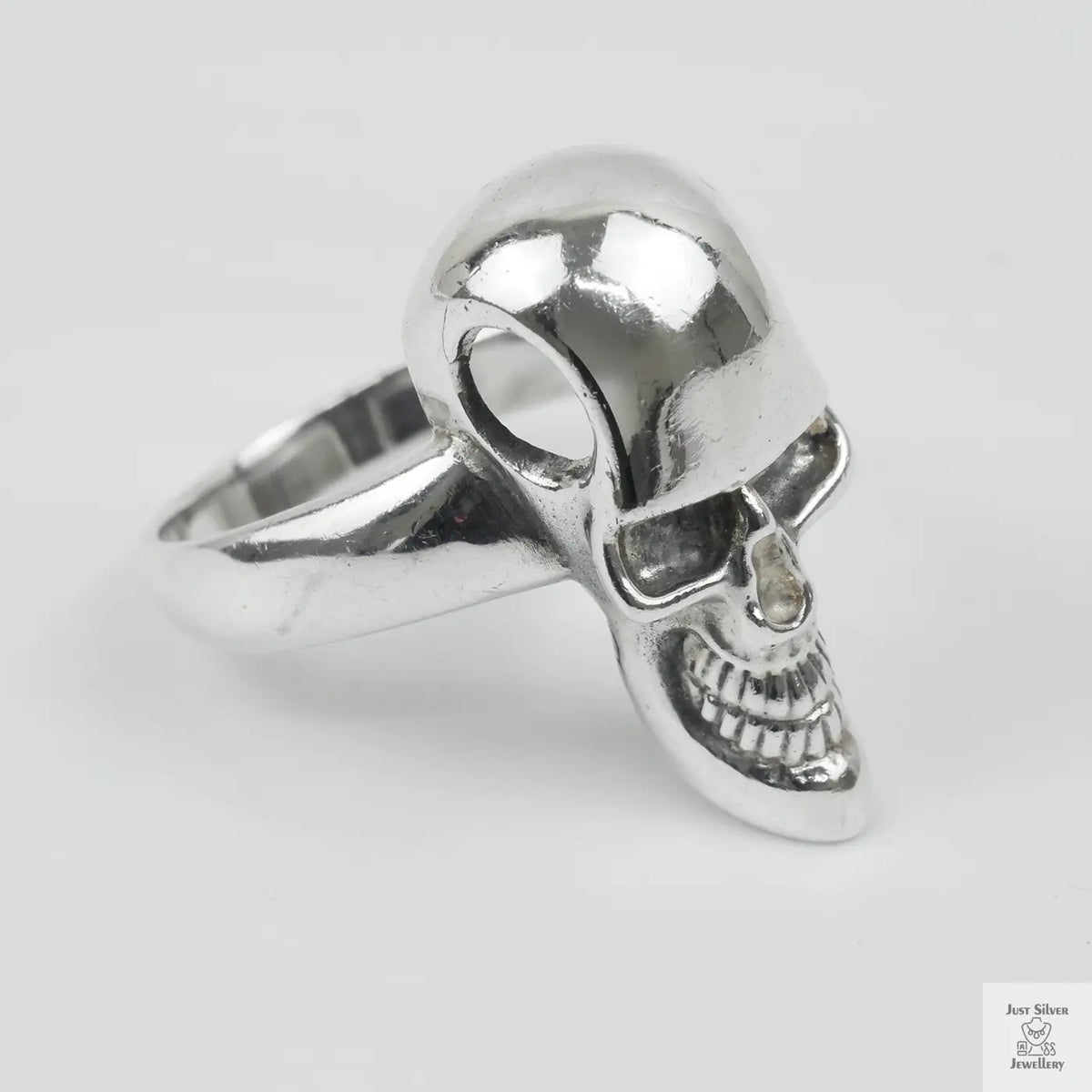 Silver skull ring on a light grey background