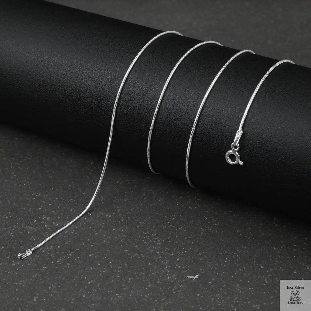 Silver fine snake necklace on a black background