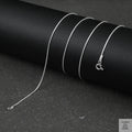 Silver fine snake necklace on a black background