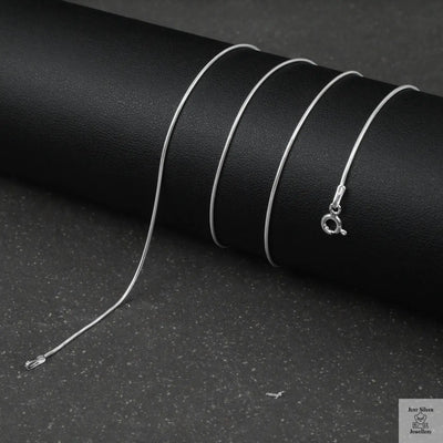 Silver fine snake necklace on a black background
