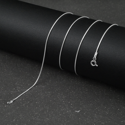 Silver fine snake necklace on a black background