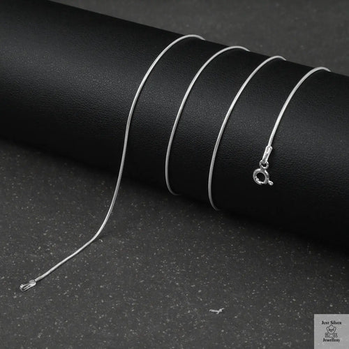 Silver fine snake necklace on a black background