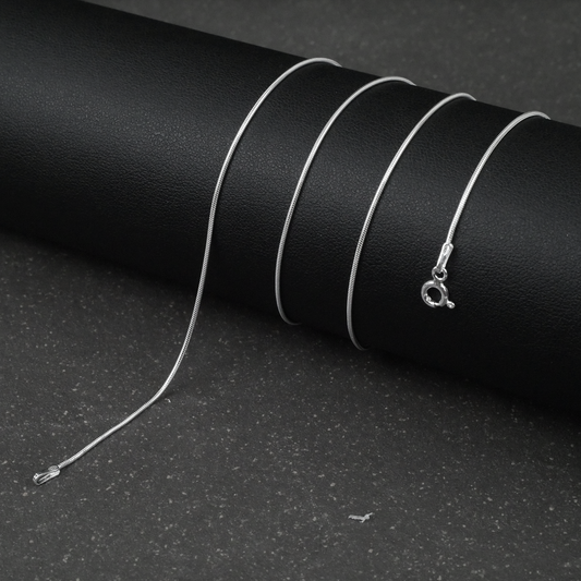 Silver fine snake necklace on a black background