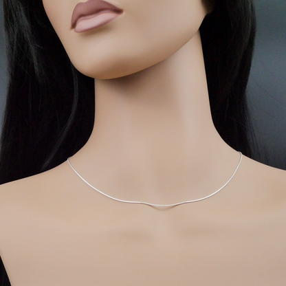 Mannequin wearing a silver snake necklace against a neutral background