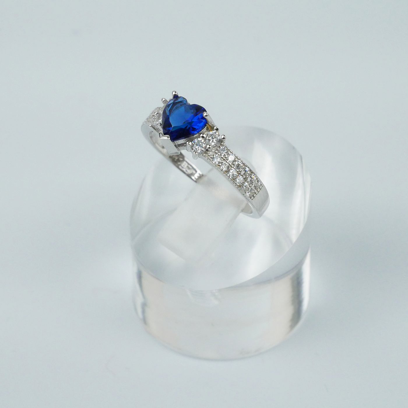 Silver ring with a blue heart-shaped gemstone on a white background
